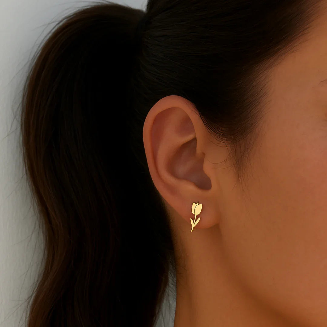 Model met gouden tulp oorknopjes van stainless steel met minimalistisch bloemdesign van Casa Jadel