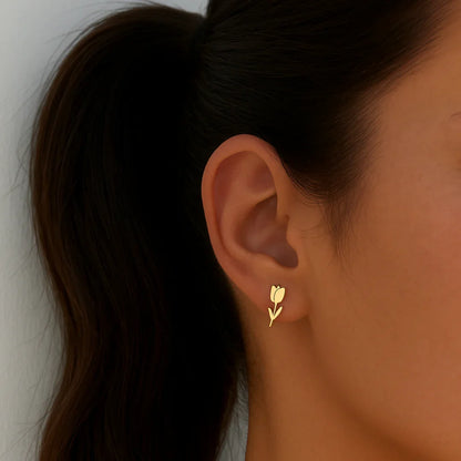 Model met gouden tulp oorknopjes van stainless steel met minimalistisch bloemdesign van Casa Jadel