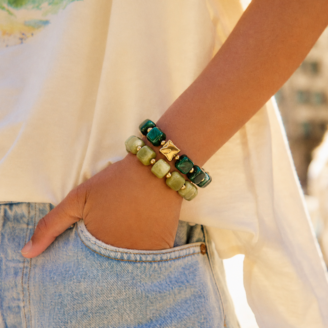 arm met donkergroene en Olijfgroene chunky kralenarmband met gouden kraal