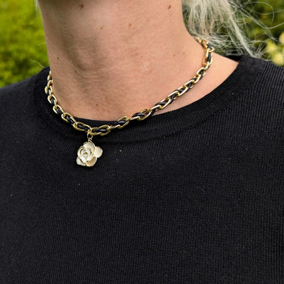 Schakelketting met rubberen koord er doorheen geregen met een bloem bedel