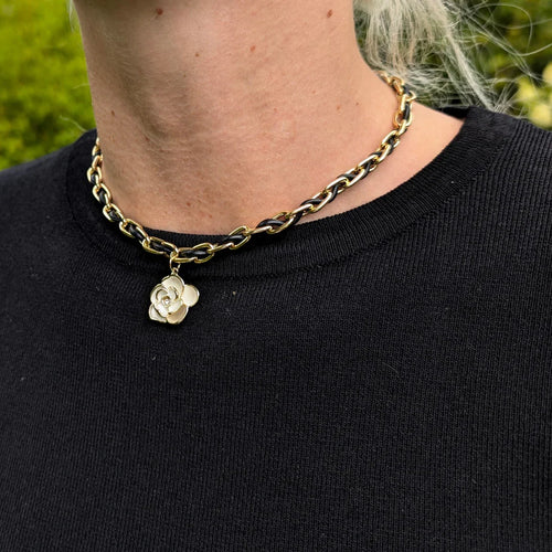 Schakelketting met rubberen koord er doorheen geregen met een bloem bedel