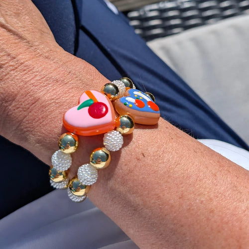 Armband goudkleurige en parelmoer kralen hartvormig roze bedel