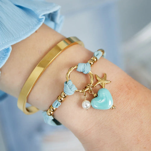 Licht blauwe armband van stof met blauw hart gouden zeester en parelkraaltje