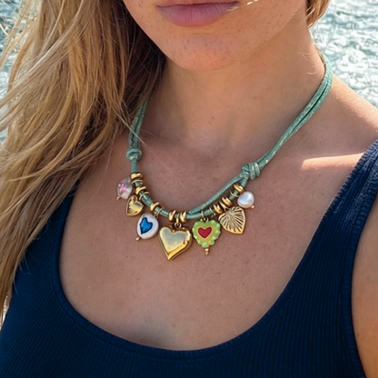 Model draagt rope ketting turquoise met glazen en gouden hart bedels. 