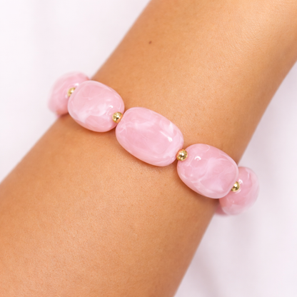 arm met Roze kralenarmband met marmerlook en gouden tussenkralen 