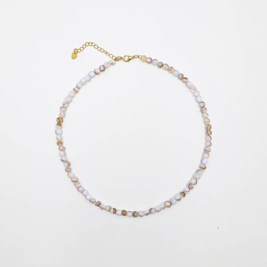 Witte natuurstenen kralenketting met kleine ronde kralen en goudkleurige sluiting op witte achtergrond