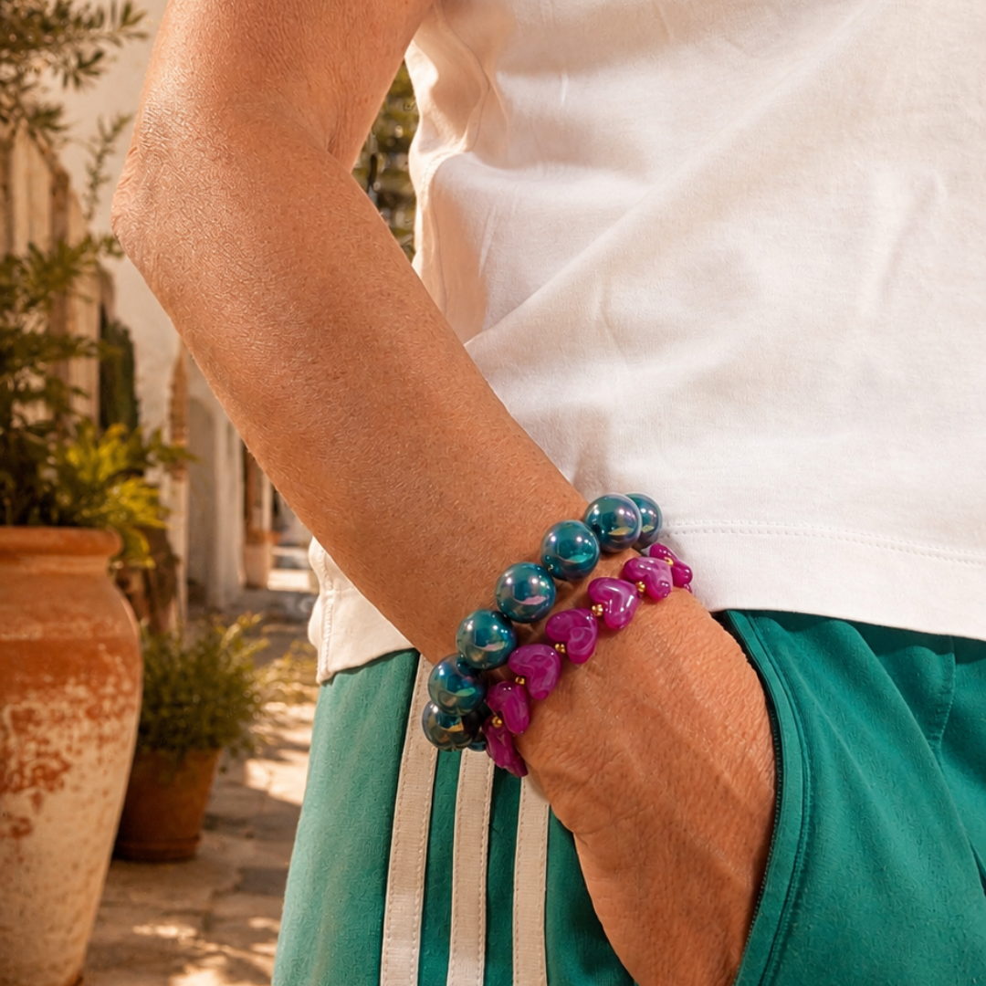 Zeegroen en hot pink statement kralenarmbanden gedragen als kleurrijke armbandenstack