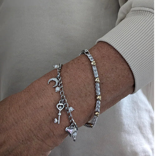 Zilveren armband met goud kleurige hartjes en zirkonen