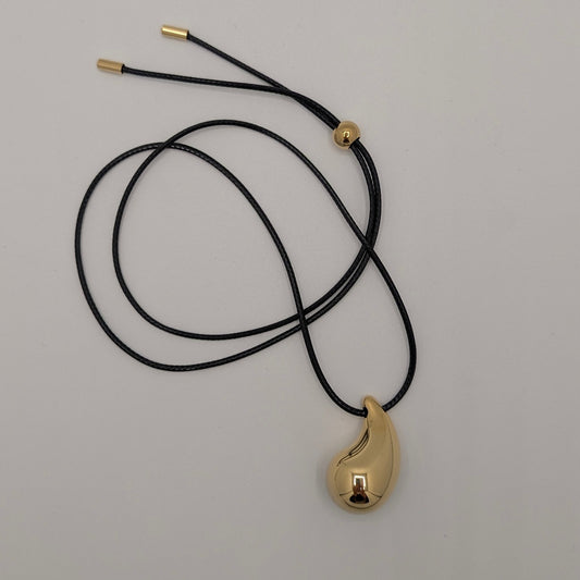 Zwart koord ketting met gouden druppel in een draai