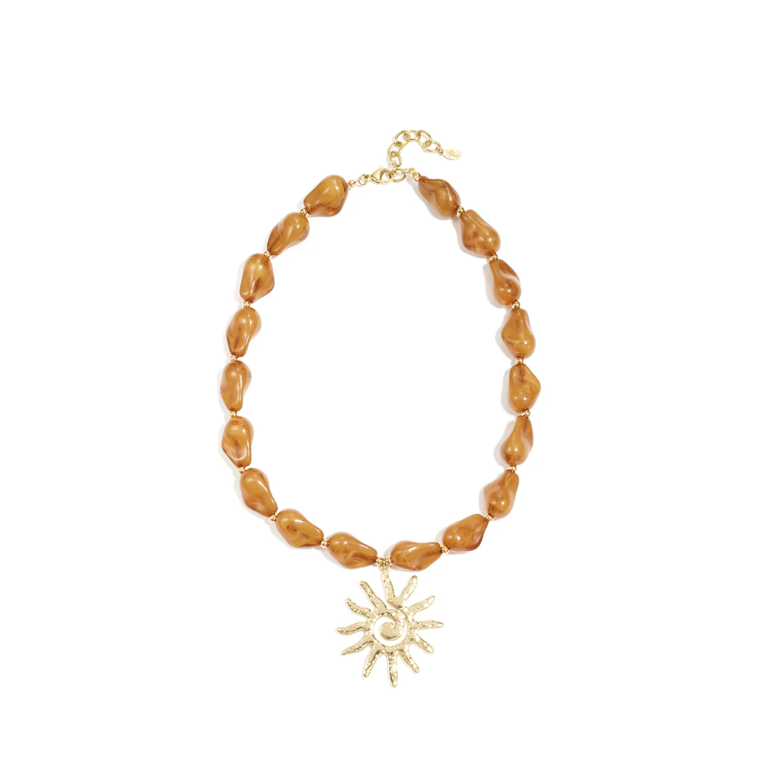 Amber bruine chunky kralenketting met grote goudkleurige zon bedel en goudkleurige details