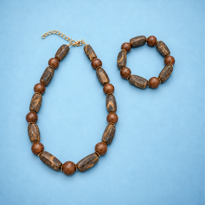 Amber-bruine long & round marble kralenketting en kralenarmband naast elkaar op een lichtblauwe achtergrond.