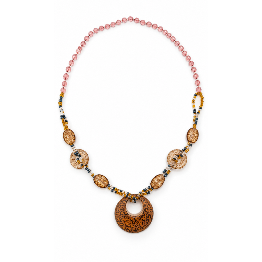 Amber lange mixed statement ketting met roze facetkralen, grote kralen met craquelé-effect en een ronde hanger met panterprint.