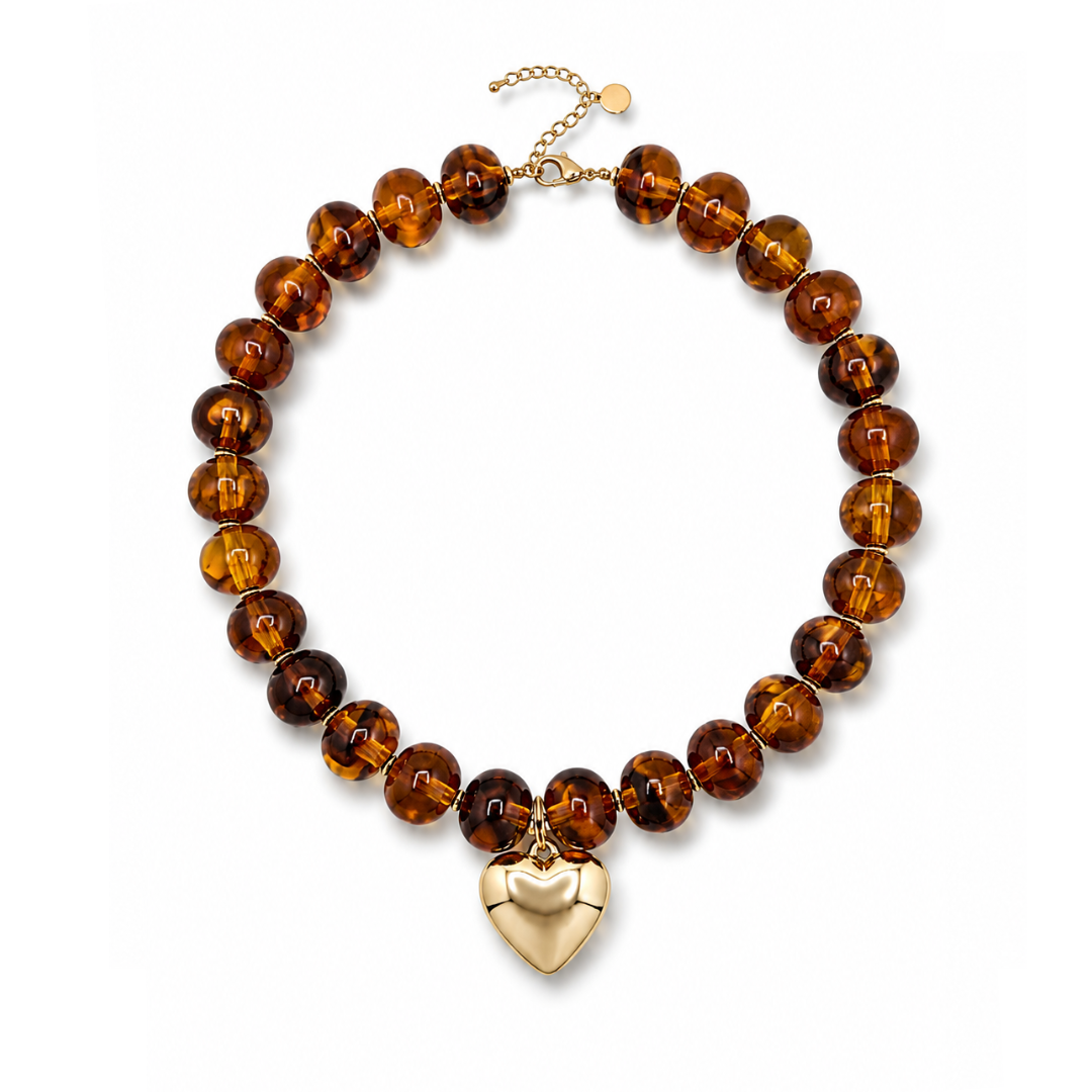 Amber ovale marble kralenketting Tes met goudkleurige hartbedel.