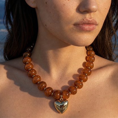 Model draagt bruine kralenketting met gouden hart bedel van Casa Jadel