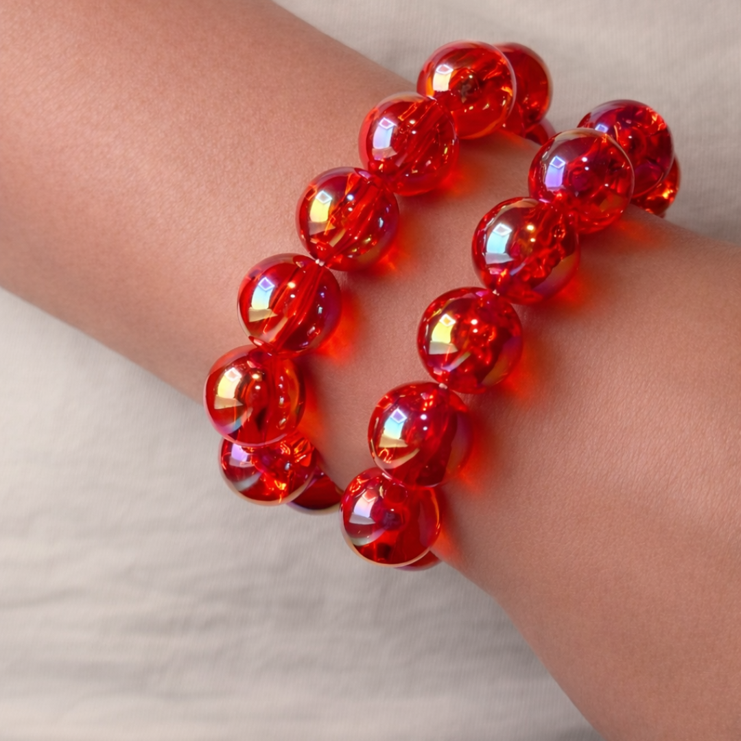 arm met  2 rood oranje kralen armbandenmet iriserende glans en grote ronde kralen 