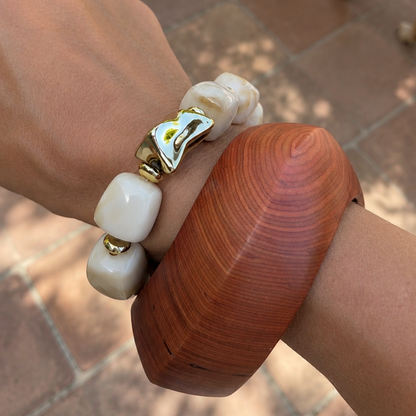 Arm met houden armband en chunky melkwitte kralen met gouden kraal armband