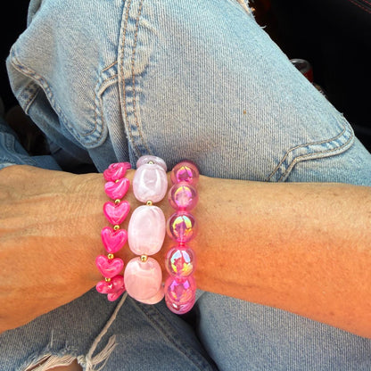 arm met roze armbanden  opspijkerbroek