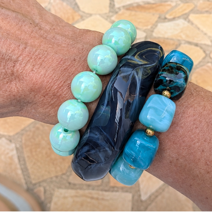 arm met turquoise groene blauwe bangle  kralenarmbanden