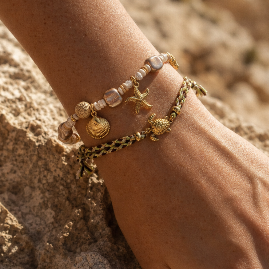 Model draagt armbanden met schelp, zeester en schildpad bedels van Casa Jadel