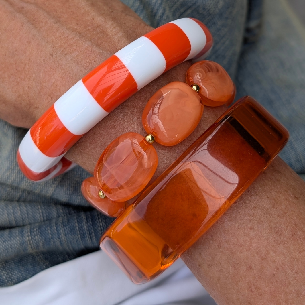 Armbandenset met oranje-wit gestreepte bangle, transparante amberkleurige bangle en oranje marble kralenarmband