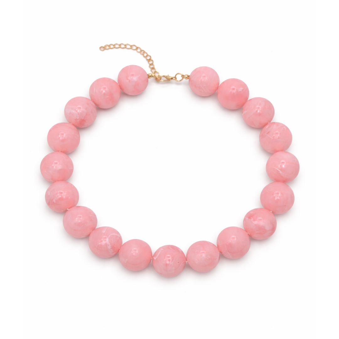 Hele grote babyroze kralenketting met grote ronde kralen en gouden sluiting op witte achtergrond