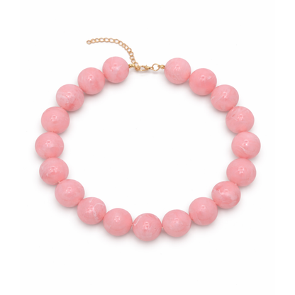Hele grote babyroze kralenketting met grote ronde kralen en gouden sluiting op witte achtergrond