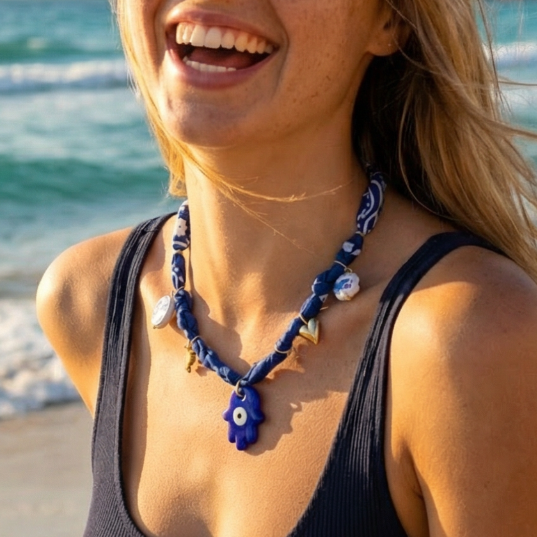 Blauwe bandana ketting met hamsa hand gedragen op het strand in boho stijl