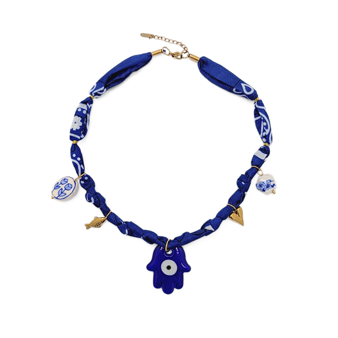ALT-tekst: Blauwe bandana ketting met hamsa hand en verschillende bedels van Casa Jadel