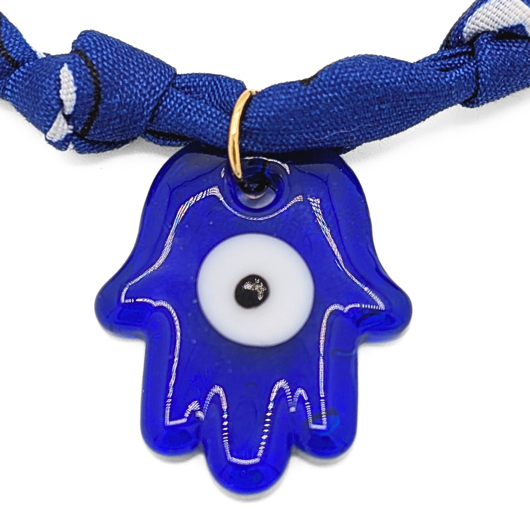 Close-up van blauwe hamsa hand bedel aan bandana ketting