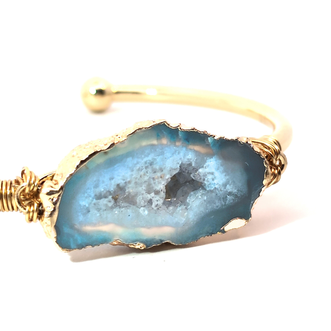 Detail van lichtblauwe agaatsteen in gouden bangle
