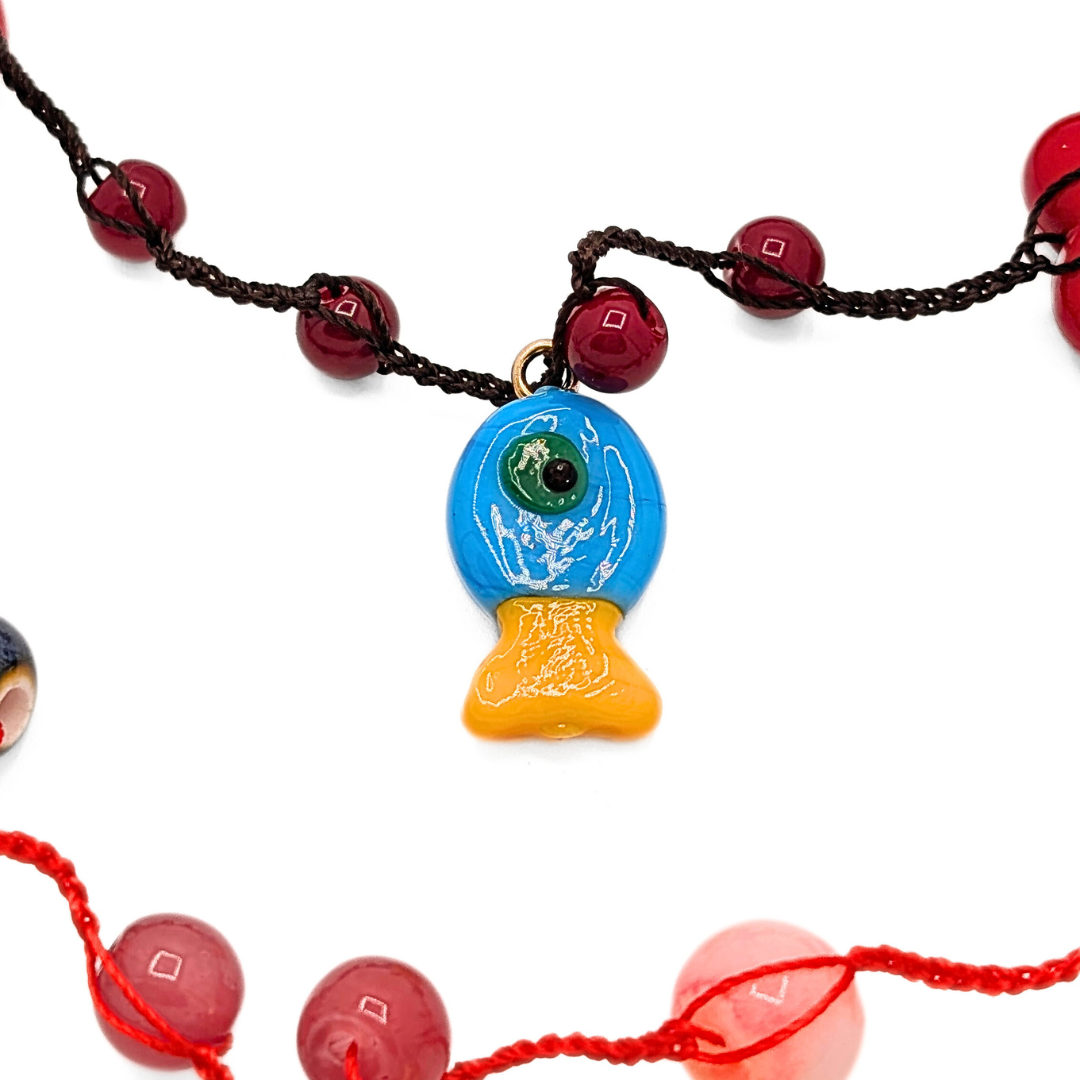 Detail bedel aan rode kralen ketting met speelse accenten Casa Jadel