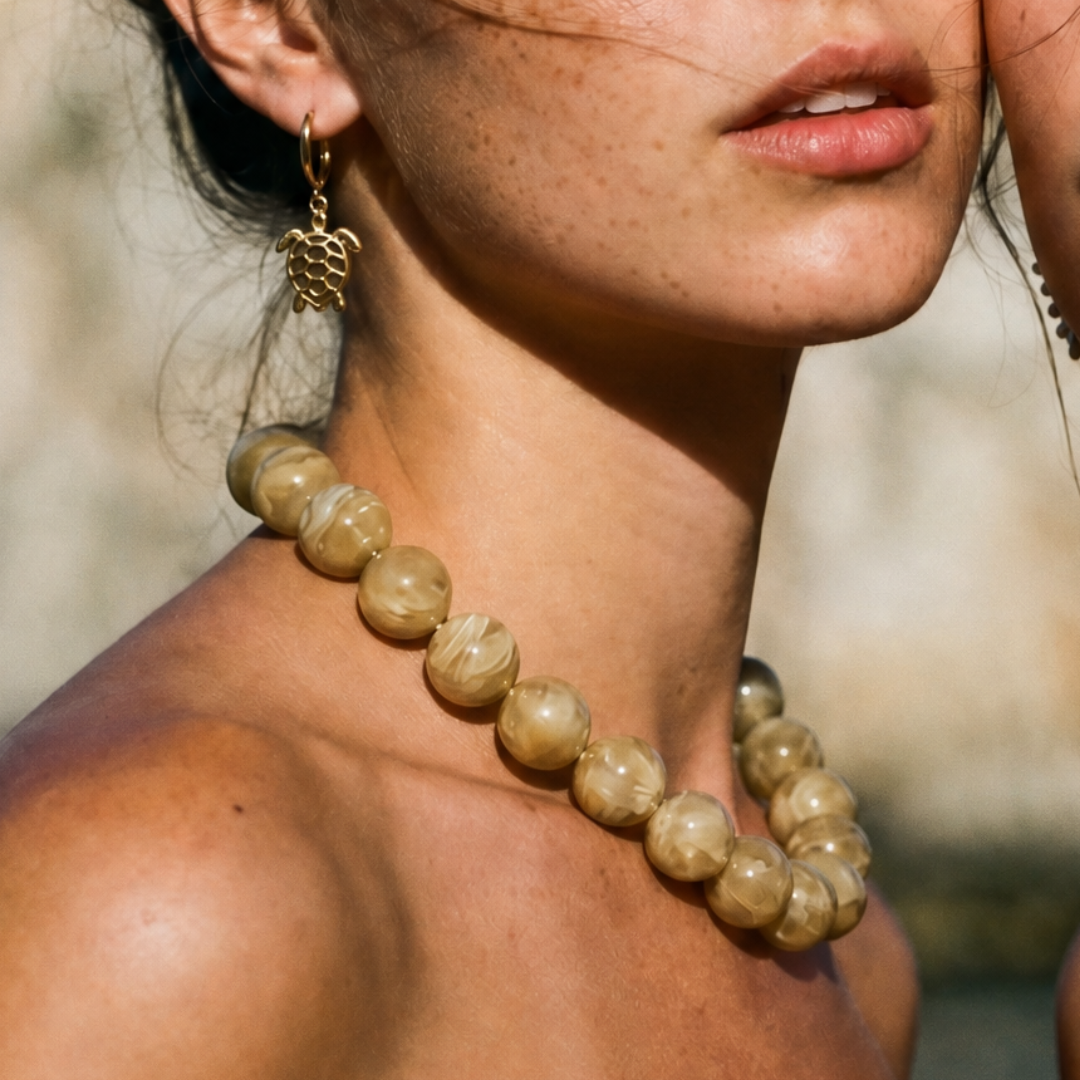 Model draagt grote kralenketting Pien met beige marble kralen. 