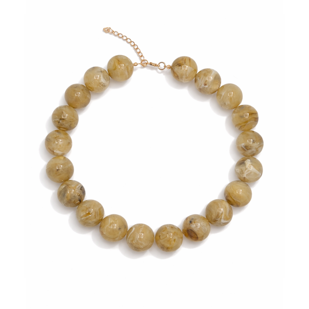 Beige grote kralenketting met marble effect en goudkleurige sluiting.