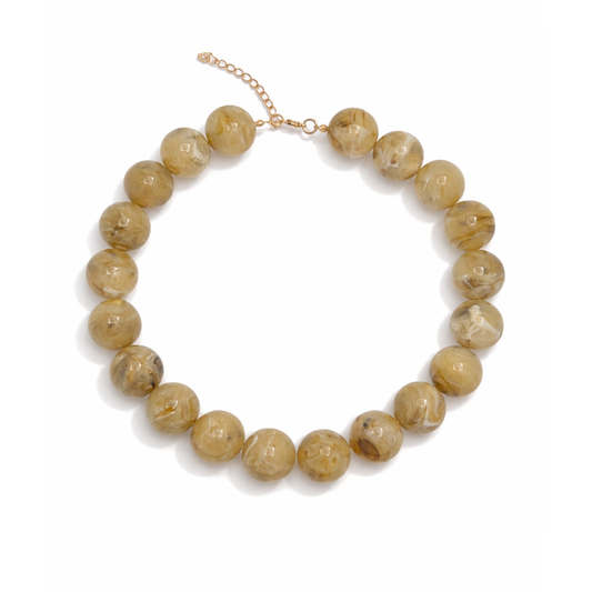 Beige grote kralenketting met marble effect en goudkleurige sluiting.