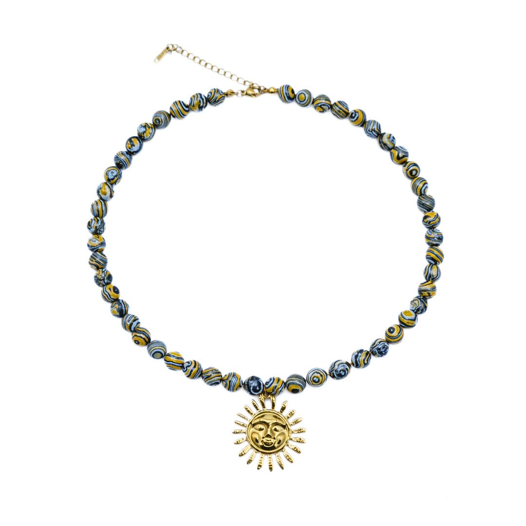 Blauw gele kralenketting met zon op witte achtergrond.