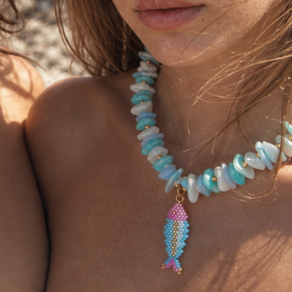Model draagt blauw witte schelpen kralenketting met kralen vis bedel van Casa Jadel