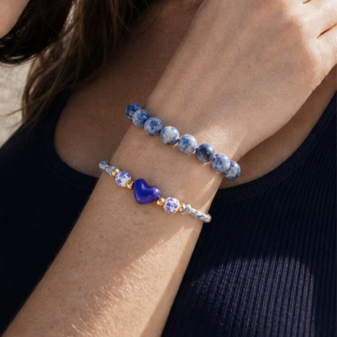 Model draagt blauwe armbanden met hartje en sodoliet kralen van Casa Jadel