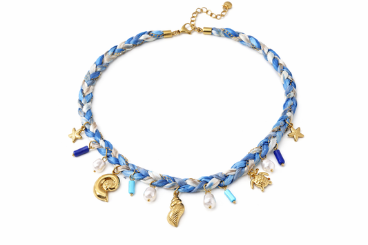 Blauwe gevlochten strandketting met schelp, zeester en parel bedels en gouden details.
