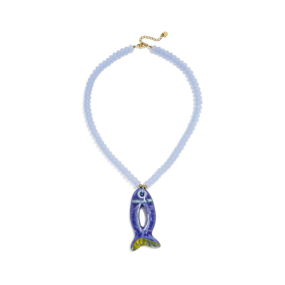 Blauwe kralenketting met lichtblauwe kralen en blauwe open keramiek vis bedel van Casa Jadel.