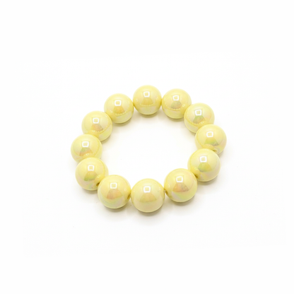botergele chunky kralenarmband met grote glanzende kralen op lichte achtergrond schuin.