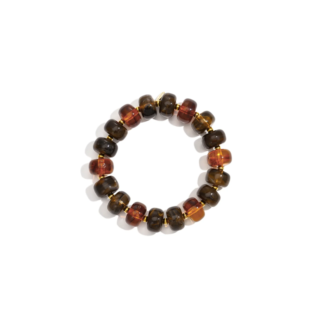 Bruin amber chunky kralenarmband Faye met glanzende kralen in chocoladebruin, cognac en transparant amber, afgewisseld met kleine gouden tussenkralen.