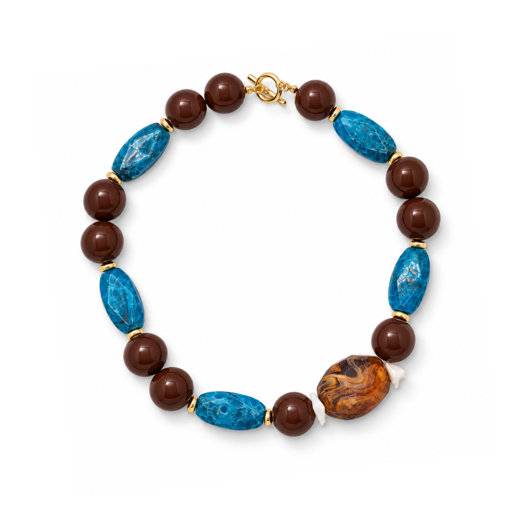 Statement kralenketting The Lodge met bruine ronde kralen, turquoise facetkralen, een amberbruine marmerkraal en goudkleurige kapittelsluiting.