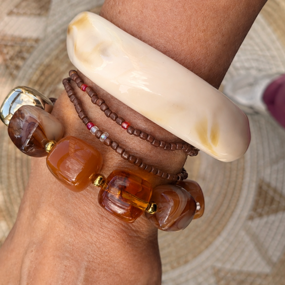 Bruine amber chunky kralenarmbandenset van Casa Jadel met crème marble bangle, amberkleurige resin kralenarmband en twee fijne bruine Miyuki armbandjes.