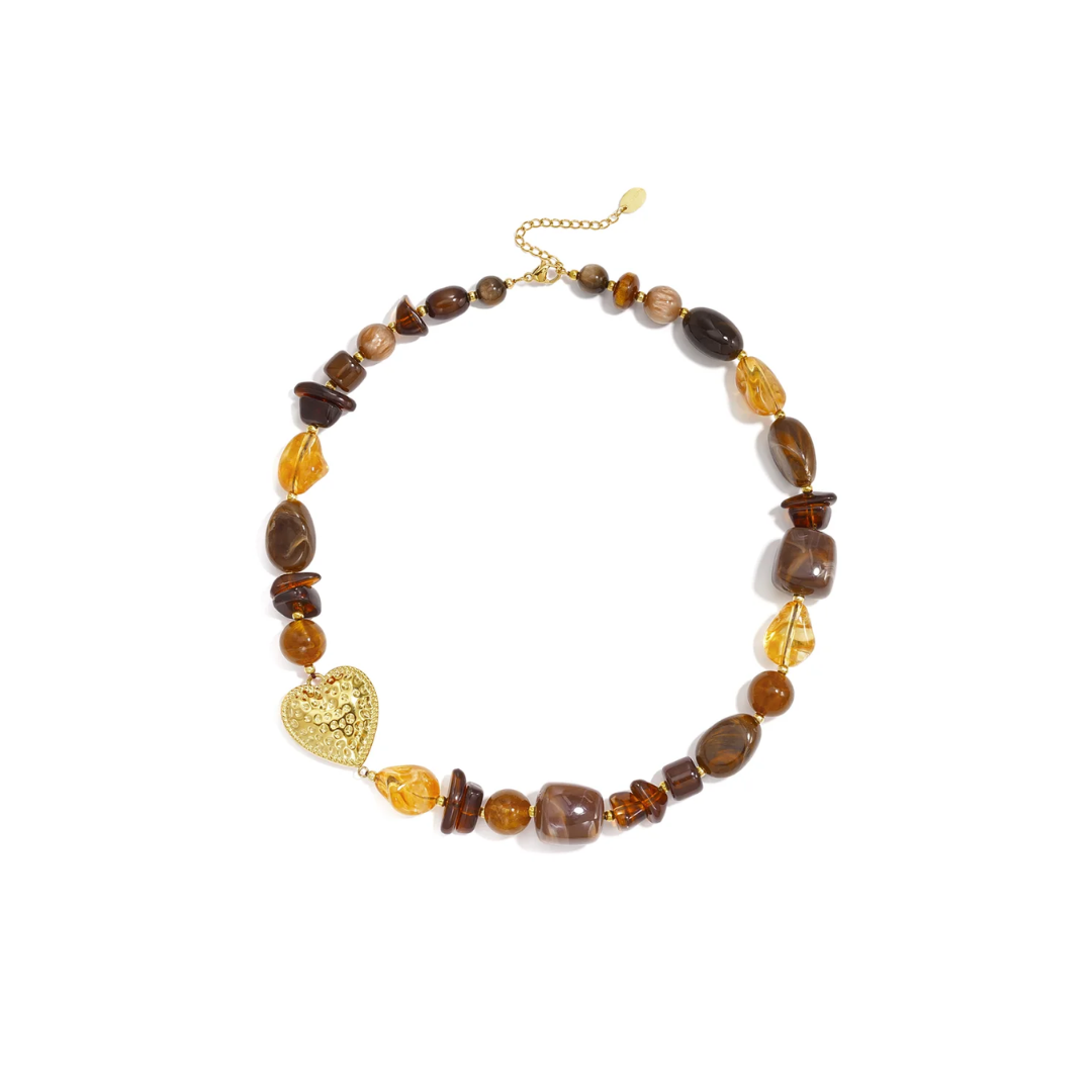 Bruine amber mixed kralenketting met transparante en gemarmerde kralen en groot goudkleurig hart met reliëf