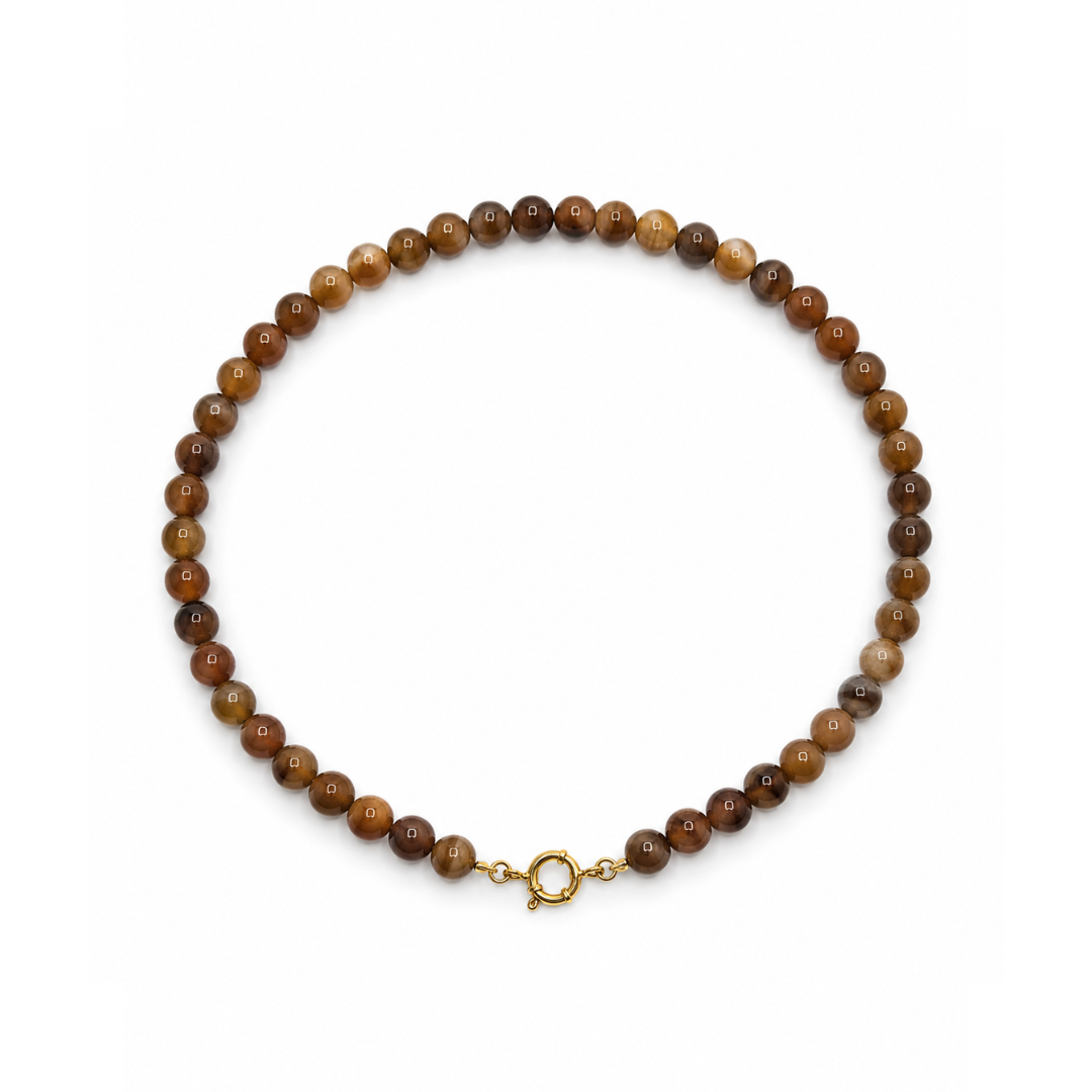 Bruine kralenketting met natuursteen-effect en goudkleurig boeislot op witte achtergrond