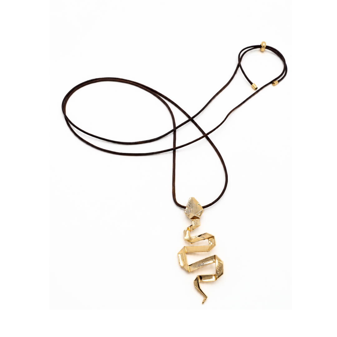 Bruine lange koordketting met een goudkleurige kronkelende slang als hanger en goudkleurige schuifkraaltjes op een witte achtergrond.