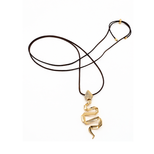Bruine lange koordketting met een goudkleurige kronkelende slang als hanger en goudkleurige schuifkraaltjes op een witte achtergrond.