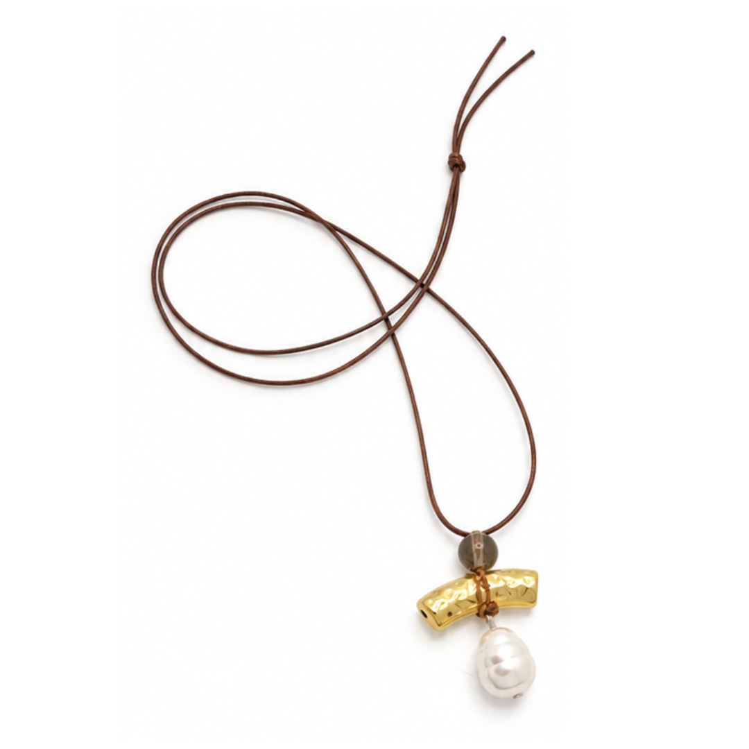 Bruine lange koordketting Totem met een rookbruine kraal, een gehamerd goudkleurig staafje en een witte barokparel op een witte achtergrond.