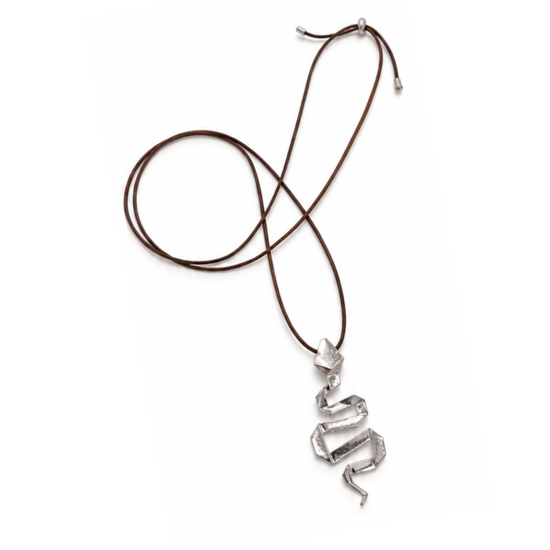 Bruine lange koordketting met een zilverkleurige kronkelende slang als hanger en zilverkleurige schuifkraal op een witte achtergrond.