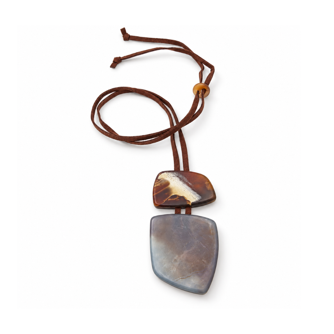 Detail van de tweedelige squared hanger met een gemarmerd amberbruin bovendeel en een groter grijsbruin onderdeel aan een leren koord.